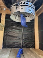 Using a ratchet clamp to keep the BBQ in position to screw it into place